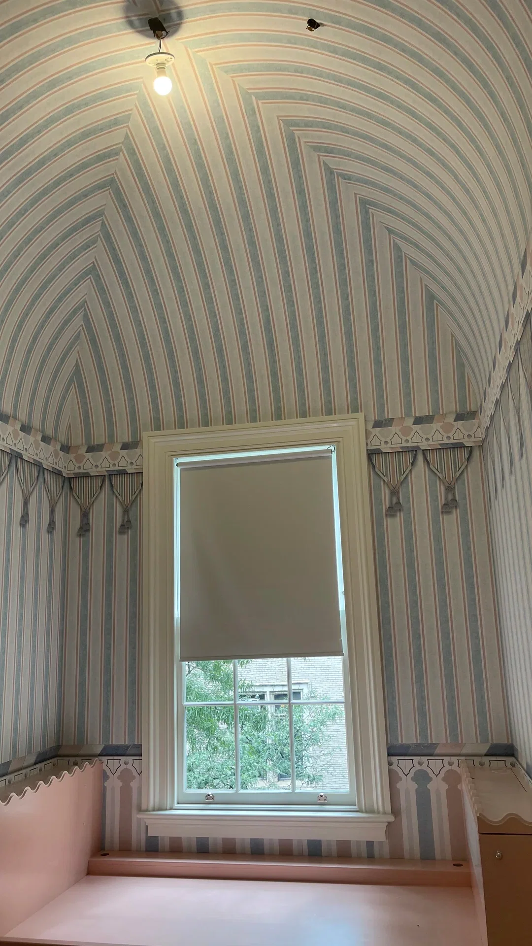 Wallpapered tall hallway with patterned ceiling treatment